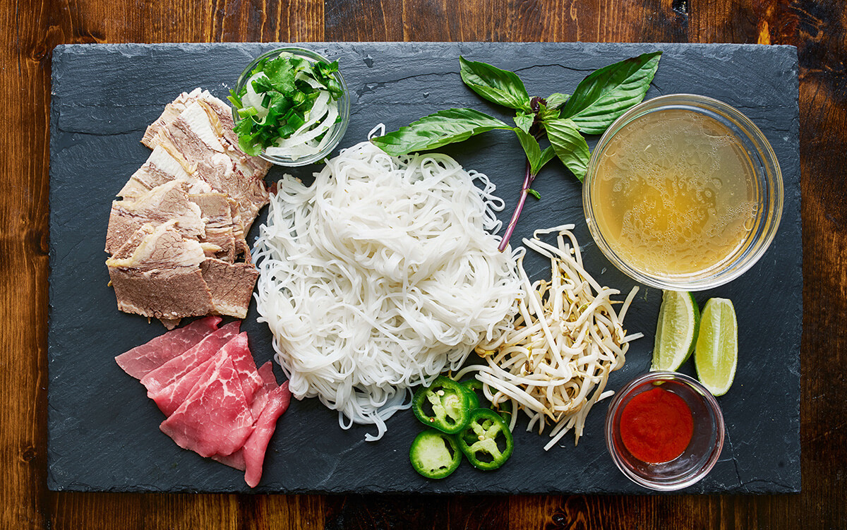 asian food items prepared for cooking and displayed on charcoal platter