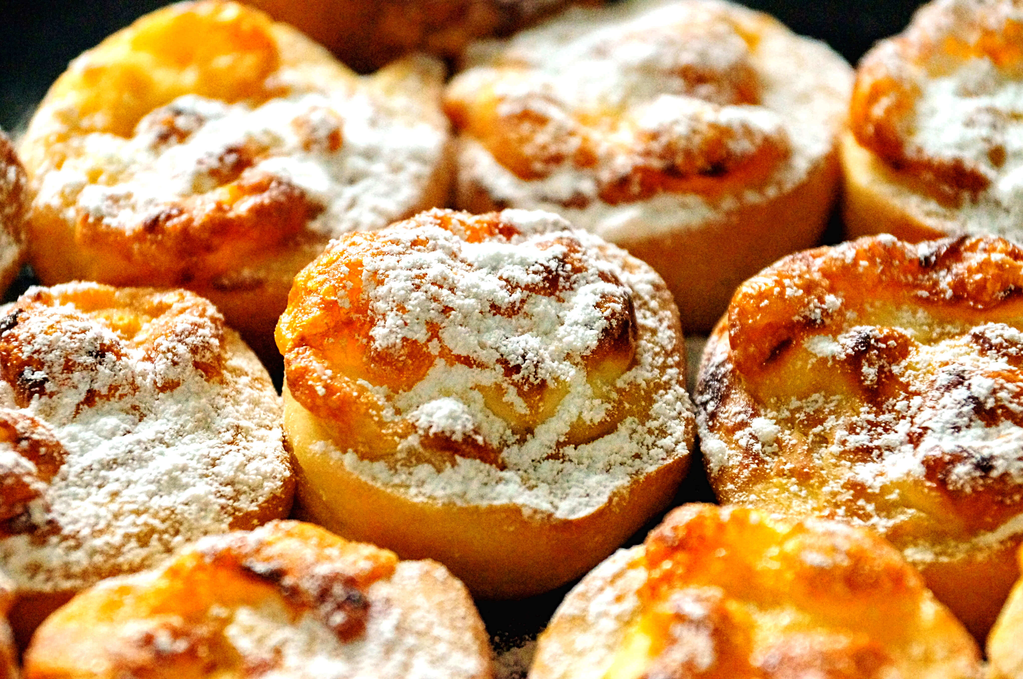 Close-up of freshly baked peach tarts dusted with powdered sugar